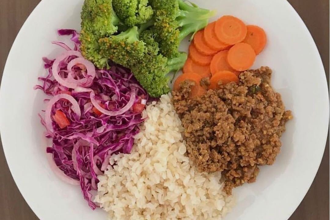 Prato com arroz integral, brócolis, cenoura, repolho roxo e carne